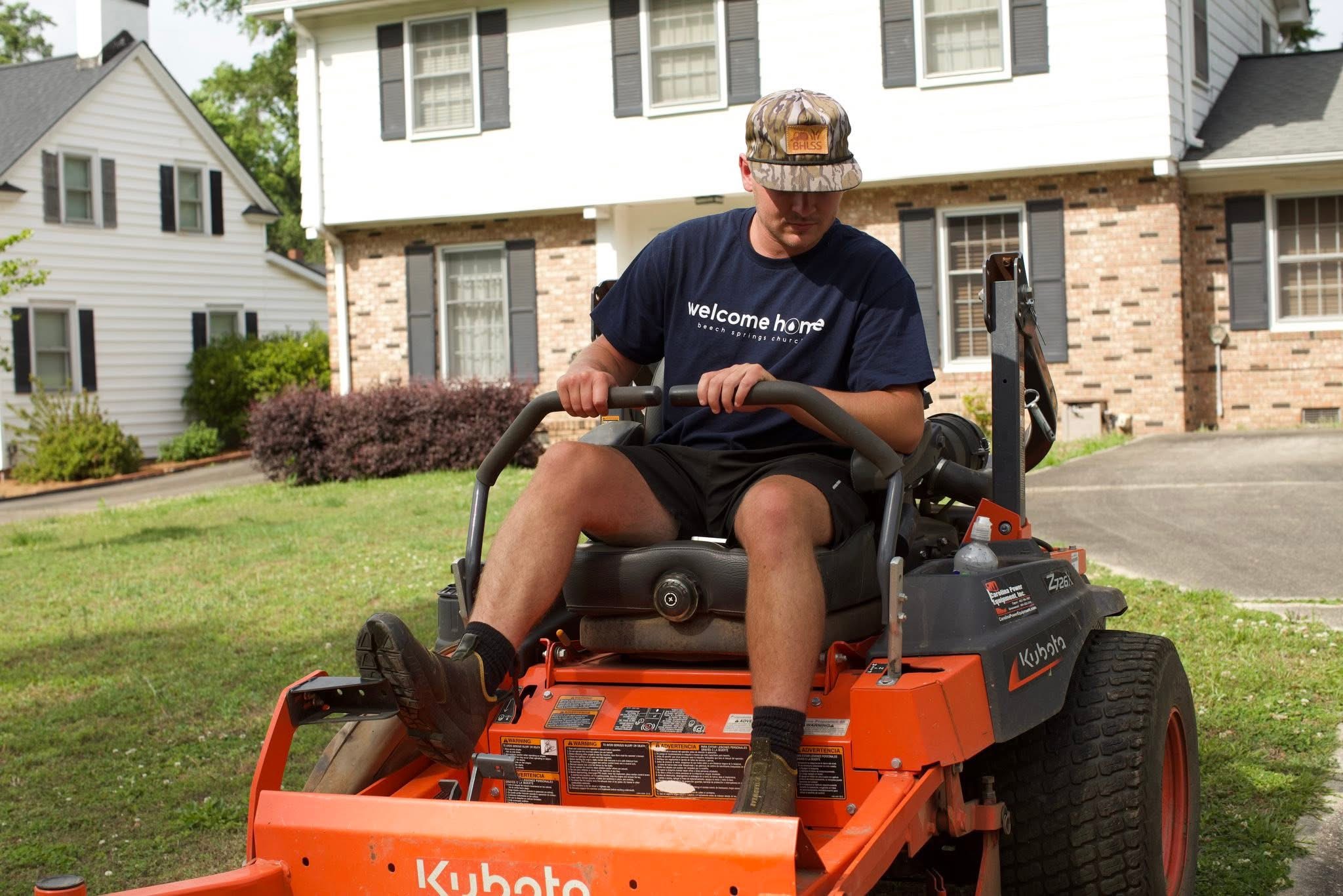 Brant Holtzclaw, owner of Brant Holtzclaw Lawn Service/Sweeping, riding a Kubota zero-turn commercial mower in a residential front yard